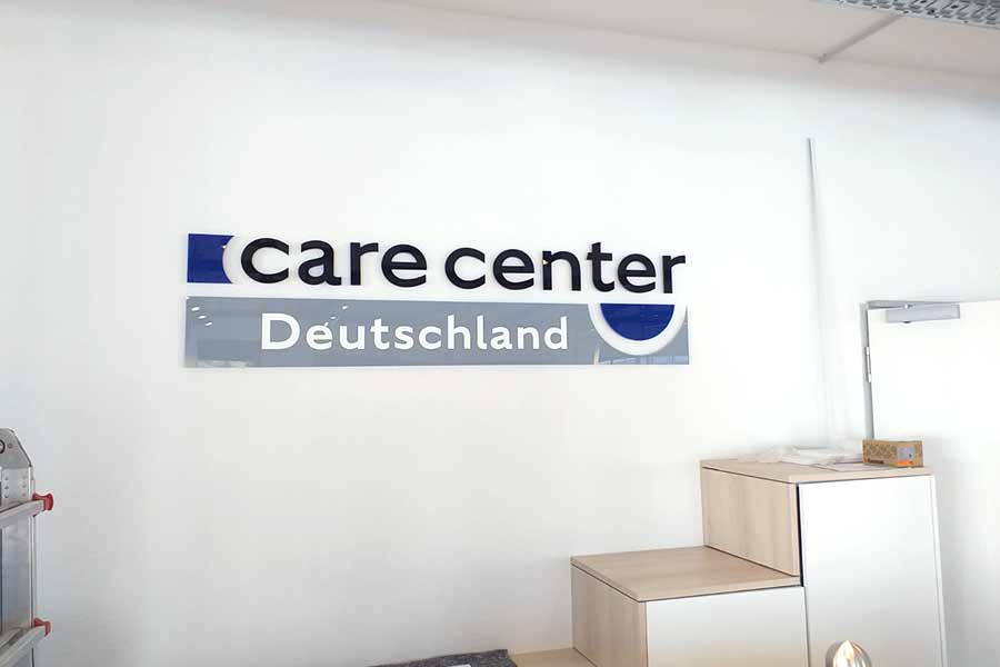 Logo Buchstaben an der Bürowand von Care Center Deutschland von Hennerkes Licht und Werbung